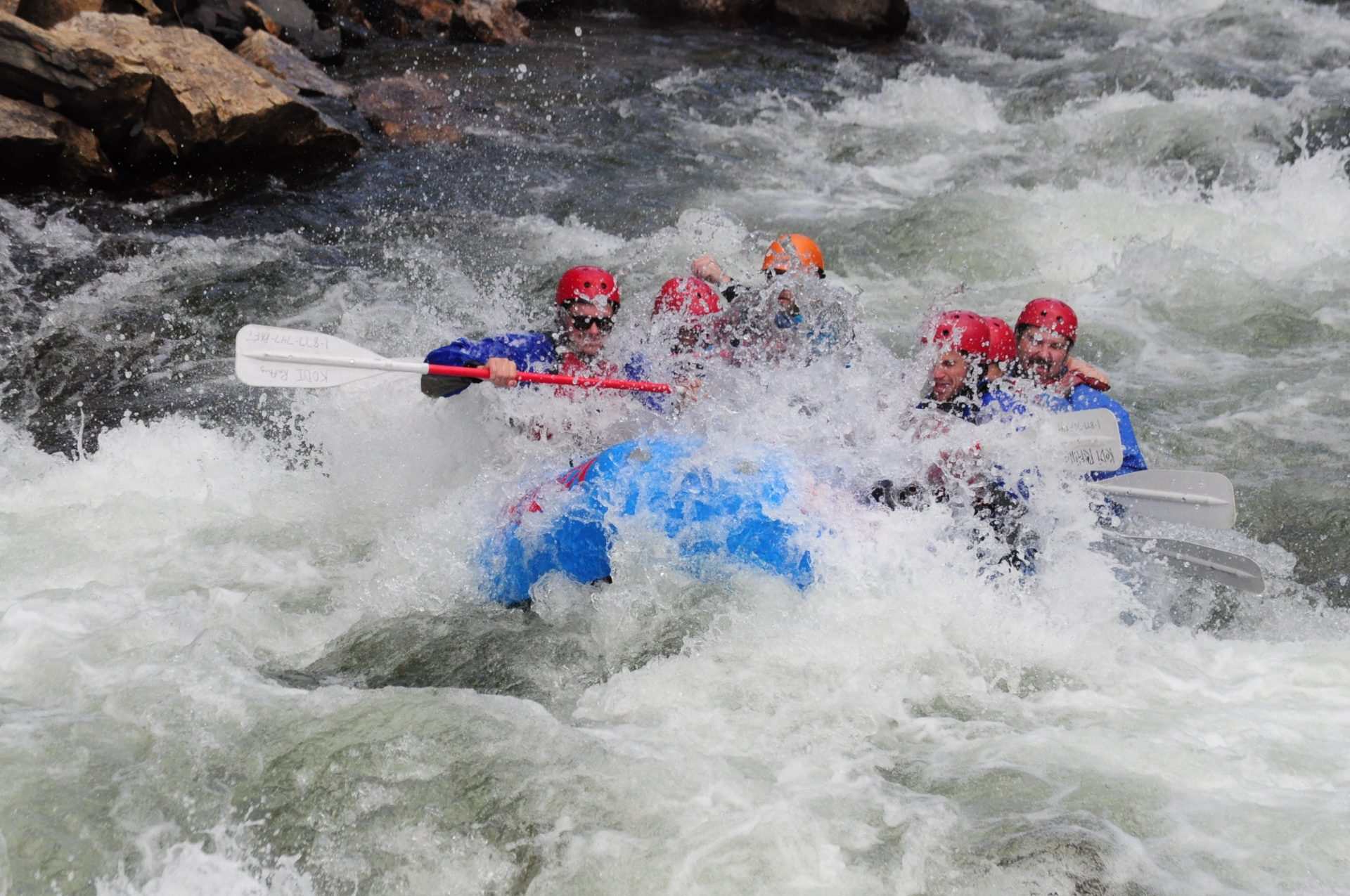 Tourists engaged in level 5 whitewater rafting in a fast stream
