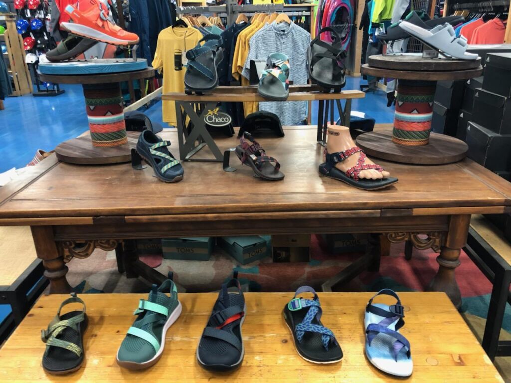 A retail store where different models of trekking shoes are presented to tourists.