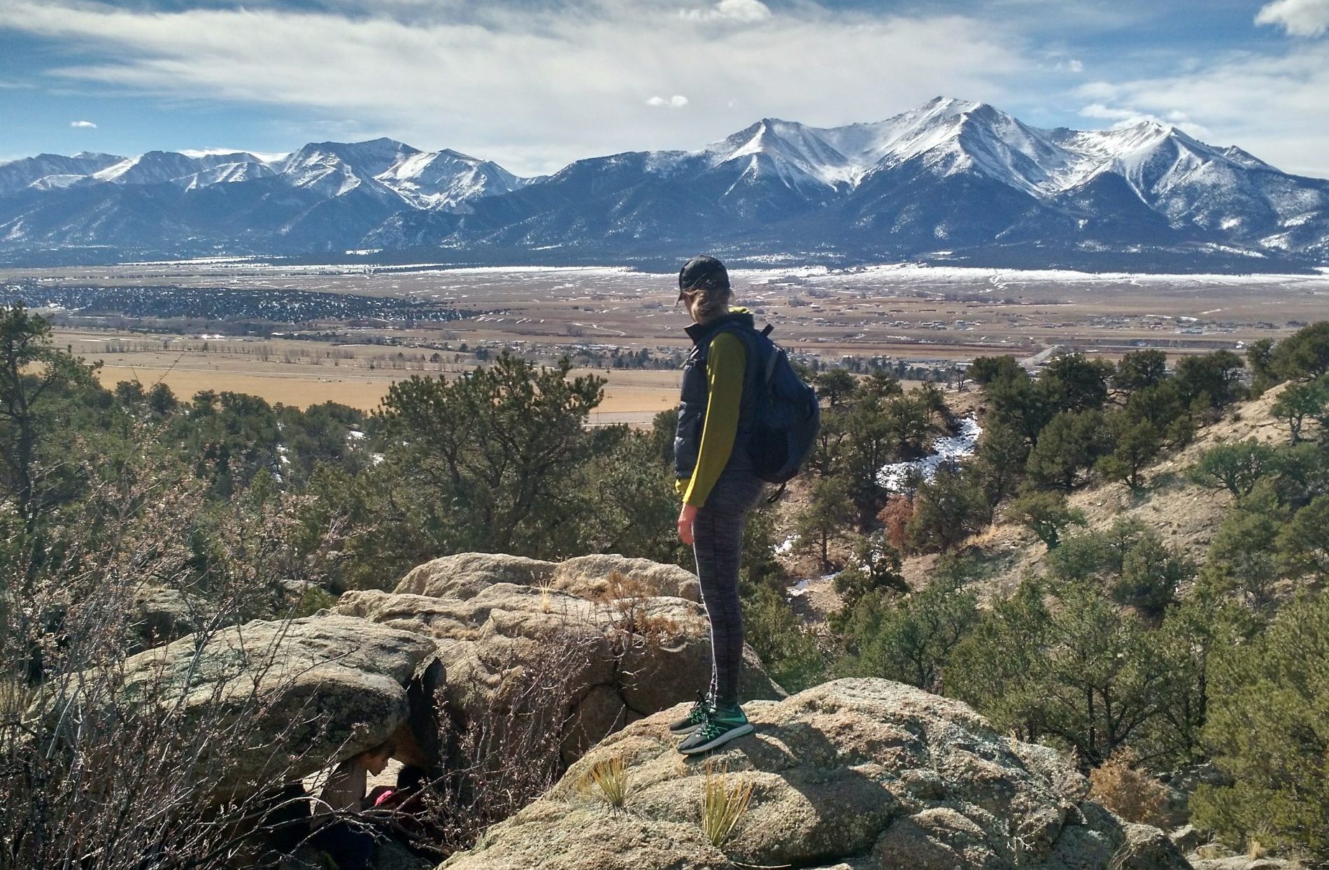 Hiker stands to take in Colorado Mountains scenery during hiking and whitewater rafting adventures