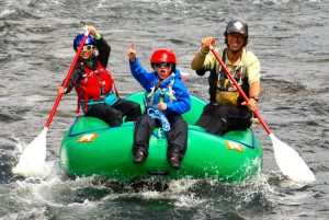 A father rafting with his two kids on a kids-friendly family whitewater rafting adventure