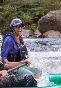 A rafting trainer smiling while teaching advanced whitewater rafting on Colorado river