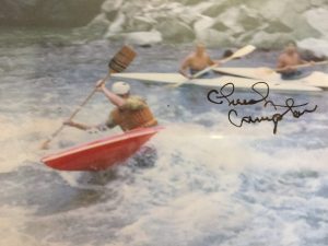 An old signed poster of people kayaking in the turbulent whitewater rapids of the Colorado river