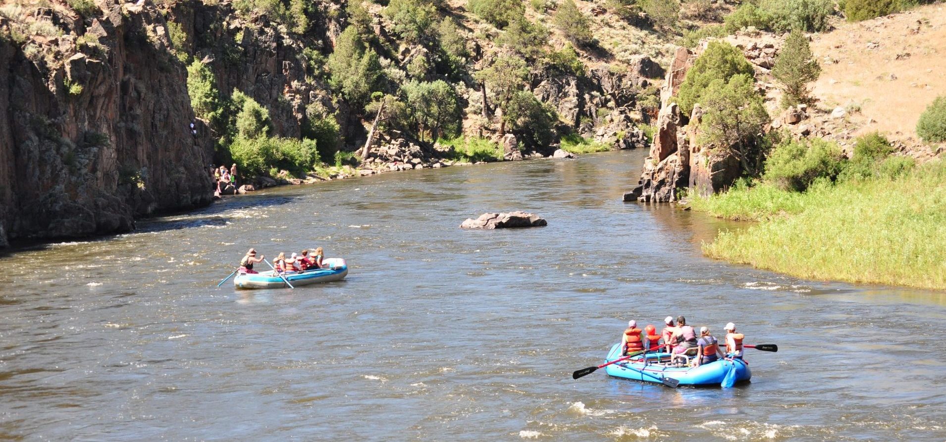 A group of tourists having fun with whitewater rafting in daytime