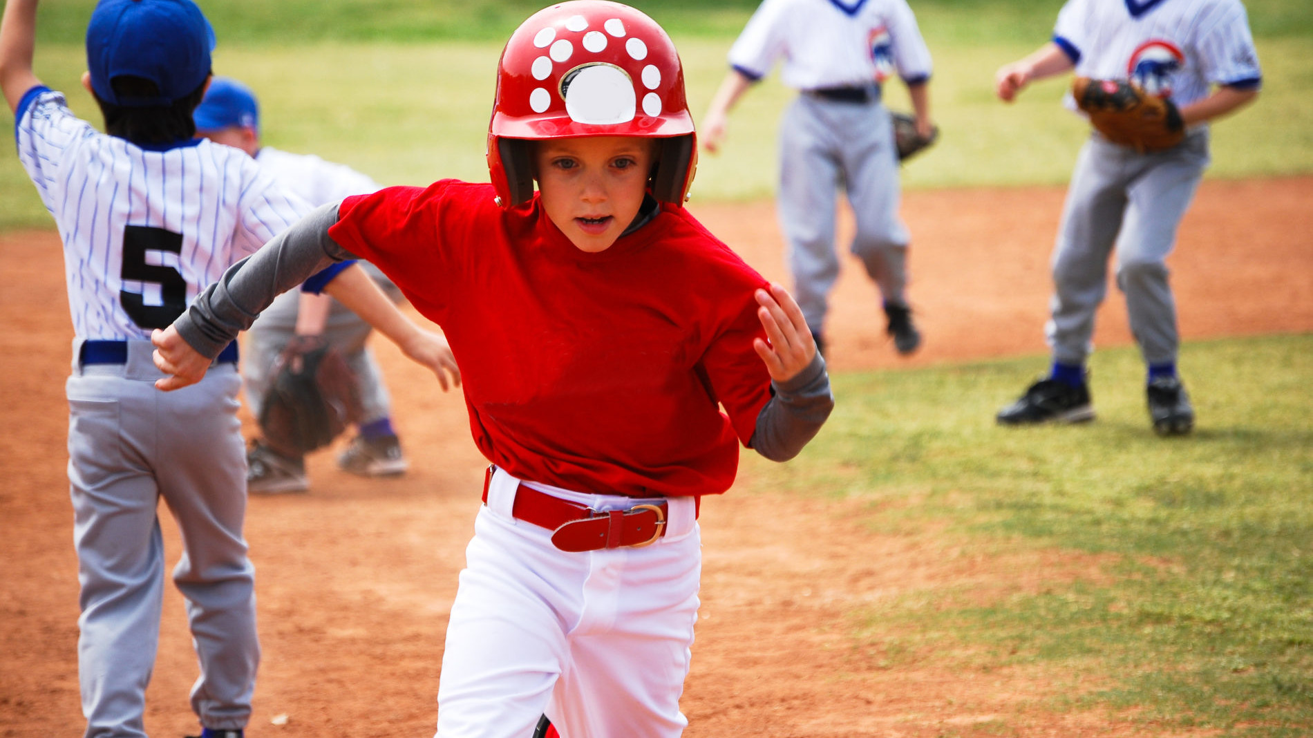 A kid running bases on a little league baseball team