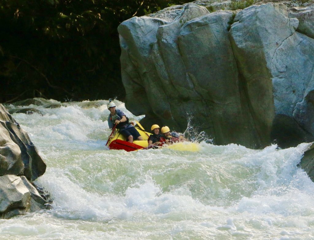 Rafting group, maneuvering through turbulent river rapids on high levels of high water rafting 